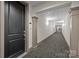 Long interior hallway with carpet and neutral walls leading to a door on the left at 4625 Piedmont Row Dr, Charlotte, NC 28210