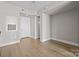 Open-concept room featuring hardwood floors, white walls, and a door at 4625 Piedmont Row Dr, Charlotte, NC 28210