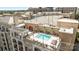 An aerial view of the rooftop pool with lounge chairs, covered dining area, and landscaped surroundings at 4625 Piedmont Row Dr, Charlotte, NC 28210