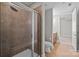 Tiled shower with glass door and rainfall showerhead, adjacent to the toilet and vanity at 4625 Piedmont Row Dr, Charlotte, NC 28210