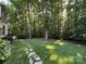 Lush backyard with stone pathway leading to a wooded area, perfect for nature lovers at 5024 Ardenwoods Dr, Charlotte, NC 28215