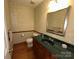 Cozy half-bath with dark vanity, mirror and sconces at 5024 Ardenwoods Dr, Charlotte, NC 28215