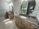 Bathroom featuring dual vanities with granite counters, modern fixtures, and tiled floors at 5024 Ardenwoods Dr, Charlotte, NC 28215