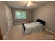 Cozy bedroom with a large window and a bed with a patterned coverlet at 5024 Ardenwoods Dr, Charlotte, NC 28215