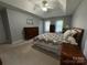 Comfortable bedroom with neutral walls, soft carpet, tray ceiling, and natural light from the windows at 5024 Ardenwoods Dr, Charlotte, NC 28215
