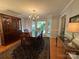 Traditional dining room with hardwood floors, a wooden dining set, a china cabinet, chandelier, and natural light at 5024 Ardenwoods Dr, Charlotte, NC 28215