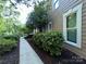 Side view of the house with professional landscaping and a walkway at 5024 Ardenwoods Dr, Charlotte, NC 28215