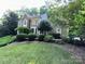 Traditional home with manicured landscaping and mature trees at 5024 Ardenwoods Dr, Charlotte, NC 28215