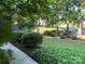 Landscaped front yard with mature trees and lush greenery creating a serene outdoor space at 5024 Ardenwoods Dr, Charlotte, NC 28215