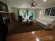 Spacious living room featuring a cozy fireplace, hardwood floors, and large windows at 5024 Ardenwoods Dr, Charlotte, NC 28215