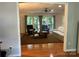 Sunlit living room with wood floors, a cozy seating arrangement, and expansive windows with backyard views at 5024 Ardenwoods Dr, Charlotte, NC 28215