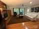 Spacious living room featuring a brick fireplace, hardwood floors, and large windows offering natural light at 5024 Ardenwoods Dr, Charlotte, NC 28215
