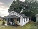 Quaint house with covered porch and attractive outdoor seating in lush, green yard at 508 E Rice St, Landis, NC 28088