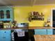 Bright kitchen featuring turquoise cabinetry, yellow walls, and butcher block countertops at 508 E Rice St, Landis, NC 28088