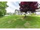 Grassy backyard with trees, landscaping, and privacy fencing, ideal for entertaining at 5129 Devonshire Rd, Denver, NC 28037