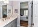 Bright bathroom featuring a gray vanity with quartz countertop and doorway view into the bedroom at 5129 Devonshire Rd, Denver, NC 28037