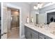 A bathroom with gray vanity, quartz countertop, large mirror, and a shower with a glass enclosure at 5129 Devonshire Rd, Denver, NC 28037
