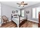 Comfortable bedroom featuring light gray walls, plantation shutters, and hardwood floors at 5129 Devonshire Rd, Denver, NC 28037