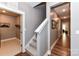 Hallway with hardwood floors, a staircase and a laundry room at the end at 5129 Devonshire Rd, Denver, NC 28037