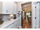 Kitchen with long counter, white cabinets, stainless steel appliances, and hardwood floors at 5129 Devonshire Rd, Denver, NC 28037