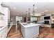 Open kitchen features white cabinets, stainless steel appliances, and large island with pendant lighting, open to the living room at 5129 Devonshire Rd, Denver, NC 28037