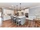 Modern kitchen featuring white cabinets, stainless steel appliances, a spacious island and hardwood floors at 5129 Devonshire Rd, Denver, NC 28037