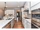 Modern kitchen featuring white cabinets, stainless steel appliances, a spacious island and hardwood floors at 5129 Devonshire Rd, Denver, NC 28037