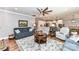 Bright living space with hardwood floors, a large ceiling fan, and a view into the adjacent kitchen and dining areas at 5129 Devonshire Rd, Denver, NC 28037