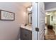 Charming powder room with a gray vanity, a framed mirror, and decorative accents adding a touch of elegance at 5129 Devonshire Rd, Denver, NC 28037