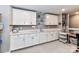 A close up of the bonus room's white cabinets, open shelving, sink, and crafting space at 5129 Devonshire Rd, Denver, NC 28037