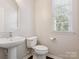 Cozy bathroom with pedestal sink, toilet, and natural light coming through the window at 570 Sixth Baxter Xing # 16, Fort Mill, SC 29708