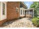 A stone patio and screened porch complement the brick facade on this home's exterior at 6612 Saunton Ct, Charlotte, NC 28277