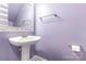 Compact half-bath with lavender walls, a pedestal sink, and a framed mirror at 6612 Saunton Ct, Charlotte, NC 28277