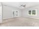 This large bedroom boasts neutral carpet and paint, a ceiling fan, and an adjacent room or office with french doors at 6612 Saunton Ct, Charlotte, NC 28277