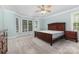 Light-filled bedroom with plush carpeting, a ceiling fan, and large windows with views at 6612 Saunton Ct, Charlotte, NC 28277