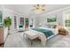 Bright bedroom with a ceiling fan, sitting area by the bay windows, and elegant decor at 6612 Saunton Ct, Charlotte, NC 28277