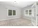 This bedroom features gray paint, carpet, and a window with white trim, offering a bright and neutral space at 6612 Saunton Ct, Charlotte, NC 28277