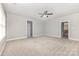 Spacious bedroom with neutral carpet and walls, featuring a ceiling fan, ample natural light, and ensuite bathroom access at 6612 Saunton Ct, Charlotte, NC 28277