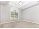 Bedroom featuring neutral walls and carpet, a large arch window with blinds, and modern recessed lighting fixture at 6612 Saunton Ct, Charlotte, NC 28277