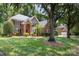 A beautiful brick home is surrounded by lush greenery, a well-manicured lawn, and mature trees at 6612 Saunton Ct, Charlotte, NC 28277