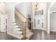 Grand foyer featuring hardwood floors, staircase, a large window, and a chandelier at 6612 Saunton Ct, Charlotte, NC 28277