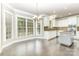 Bright kitchen with a spacious dining area featuring gray-stained wood flooring and a large set of windows at 6612 Saunton Ct, Charlotte, NC 28277