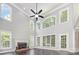Spacious living room with high ceilings, large windows, a ceiling fan, and a fireplace at 6612 Saunton Ct, Charlotte, NC 28277