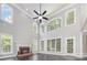 Spacious living room with high ceilings, large windows, a ceiling fan, and a fireplace at 6612 Saunton Ct, Charlotte, NC 28277