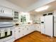 Bright kitchen features white cabinets, granite countertops, hardwood floors, and modern appliances at 101 Treeline Dr, Belmont, NC 28012