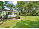 Large backyard with lush green lawn, charming pond, and mature trees, perfect for outdoor enjoyment at 1104 Pump Station Rd, Kannapolis, NC 28081