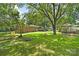 Large backyard with a fire pit, swing and storage building surrounded by mature trees and lush lawn at 1104 Pump Station Rd, Kannapolis, NC 28081