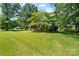 Well-manicured front yard showcasing lush lawn and mature trees, enhancing the home's curb appeal at 1104 Pump Station Rd, Kannapolis, NC 28081