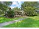 Brick home features a well manicured lawn, mature trees, and walkway to a covered porch at 1104 Pump Station Rd, Kannapolis, NC 28081
