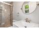 Modern bathroom featuring a tiled shower, brushed nickel fixtures, and a stylish round mirror at 1138 Laurel St, Salisbury, NC 28144